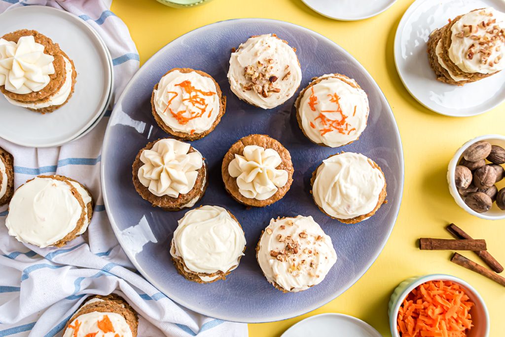 overhead serving platter of carrot cakes garnished with carrots, nuts and frosting