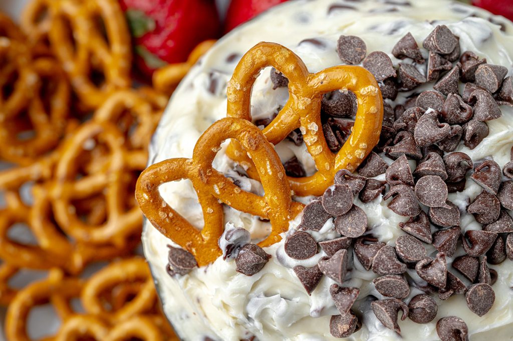 close up of pretzels in chocolate chip cookie dough dip