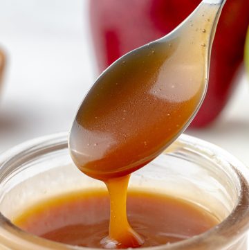 spoon with easy caramel sauce recipe in a glass jar