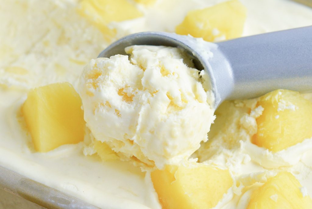 close up of ice cream scoop with pineapple ice cream