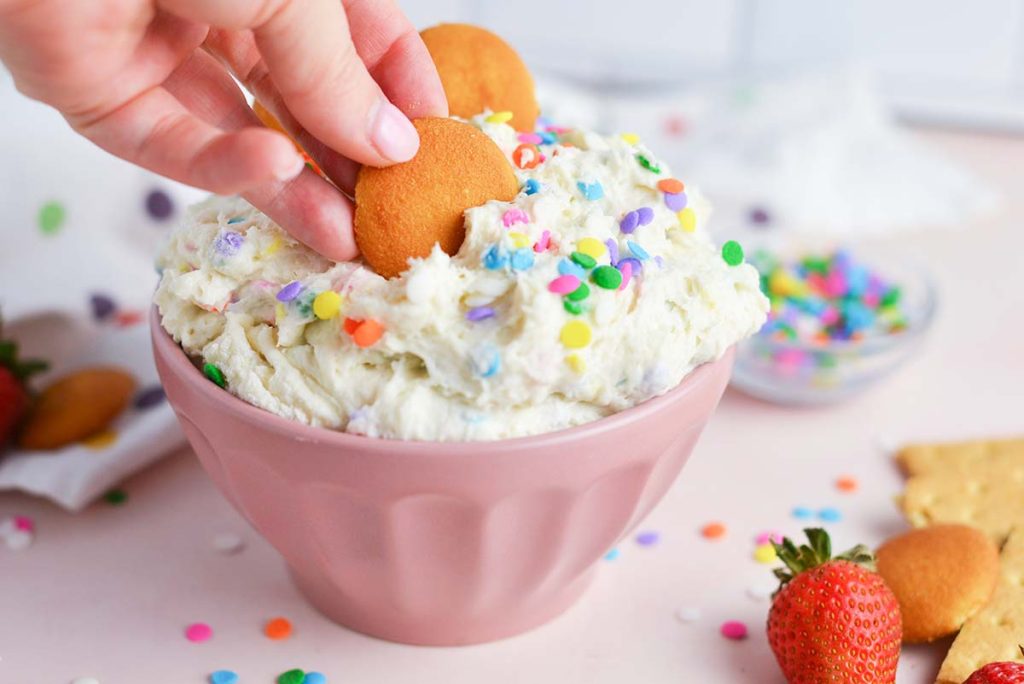 vanilla wafer dipping into cake batter dip