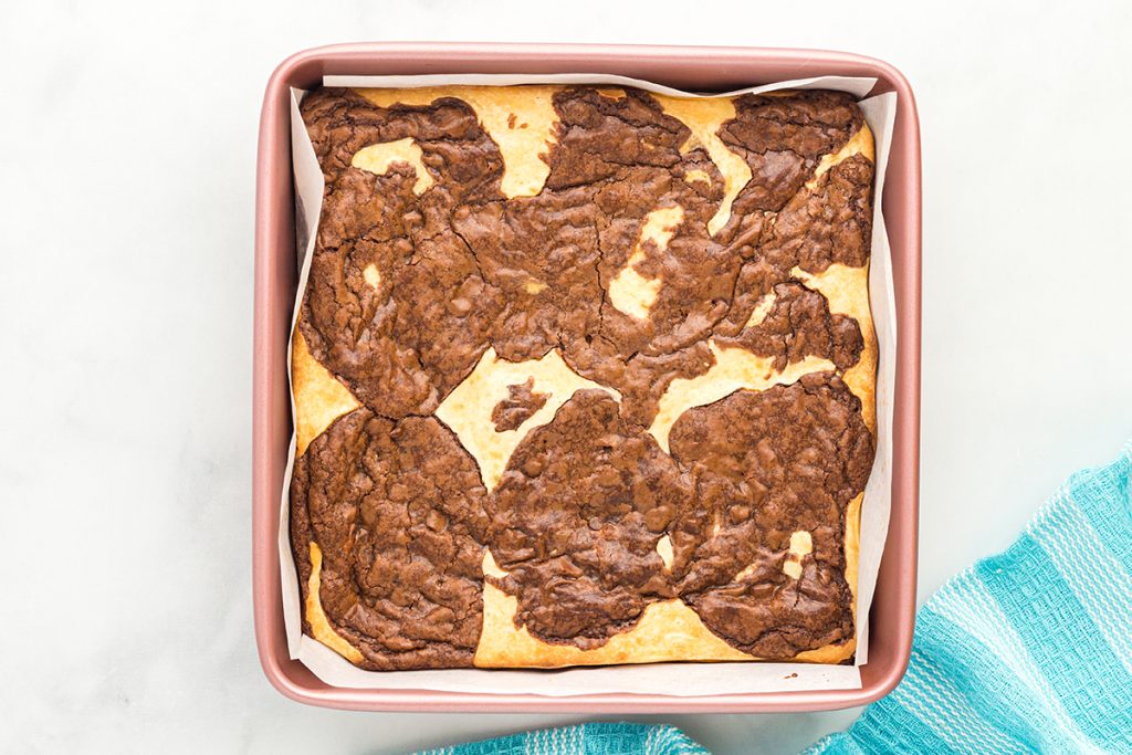 baked brownie cheesecake bars in a pan