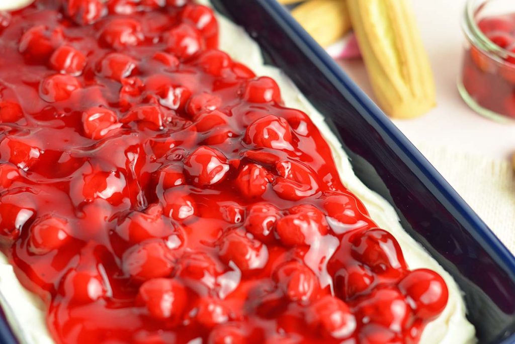 angle close up of cherry filling over vanilla cheesecake dip