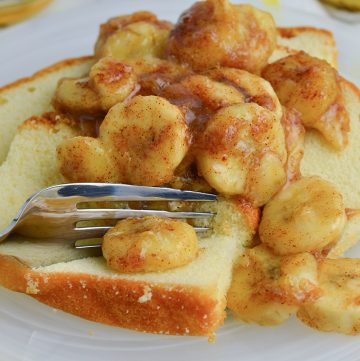 fork cutting into pound cake topped with cinnamon bananas