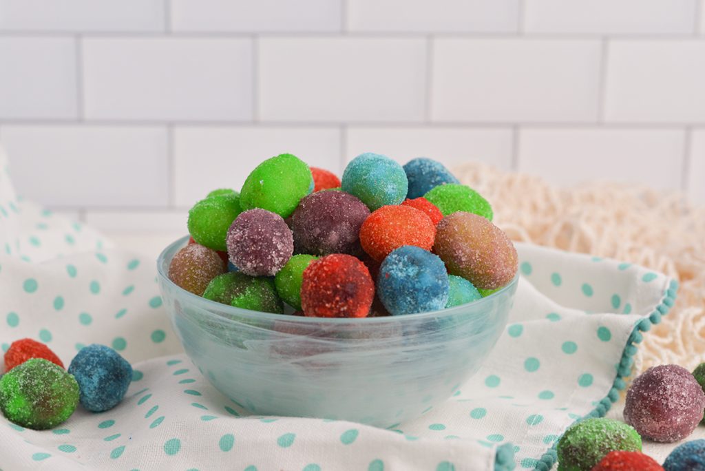different colored jello grapes in a blue bowl