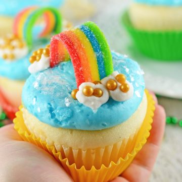 hand holding one rainbow cupcake