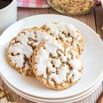 three iced oatmeal cookies on a plate