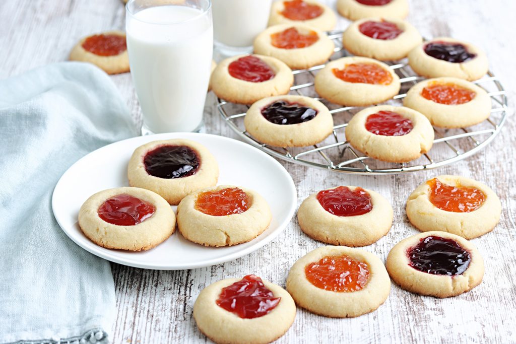 thumbprint jam cookies on a plate and cooling rack