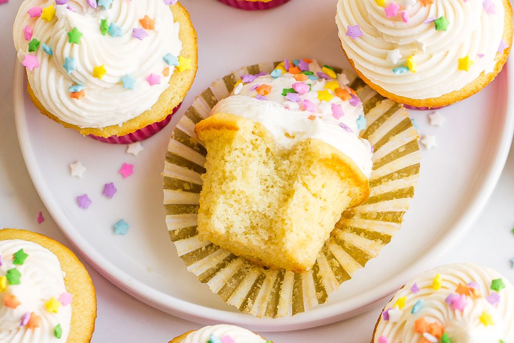 close up of bite taken out of vanilla cupcake