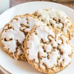 three iced oatmeal cookies on a plate