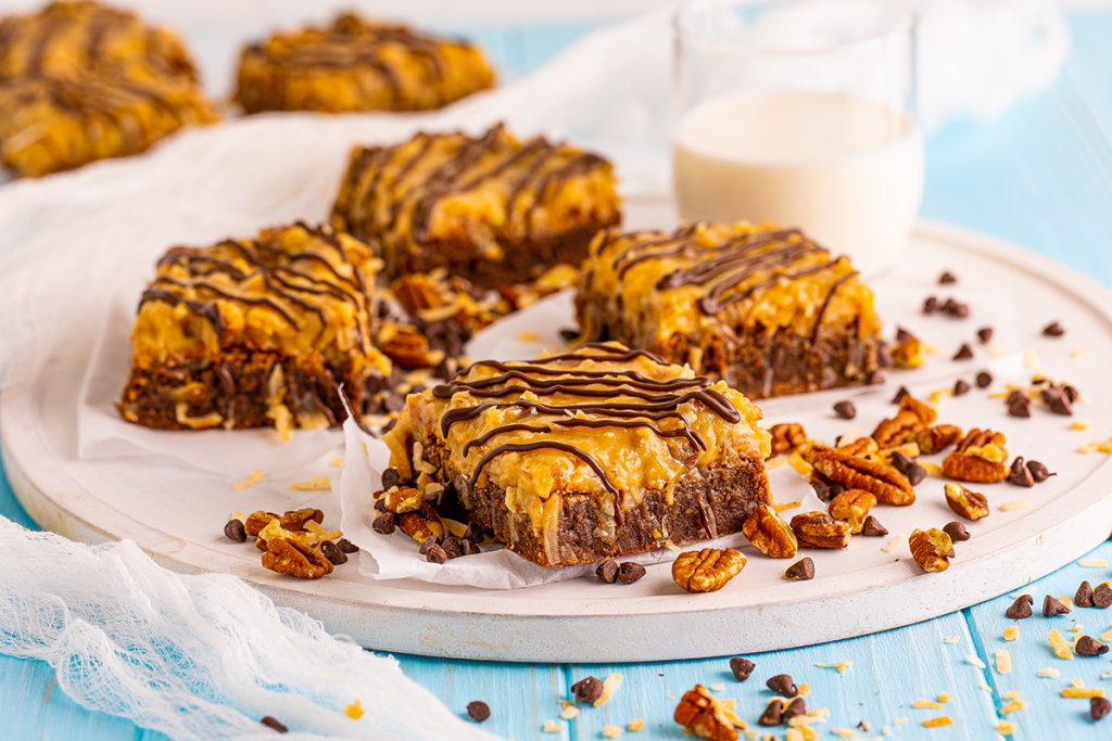 four german chocolate brownies on a tray with milk