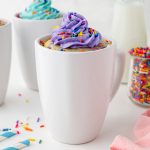 straight on shot of vanilla mug cake with purple frosting