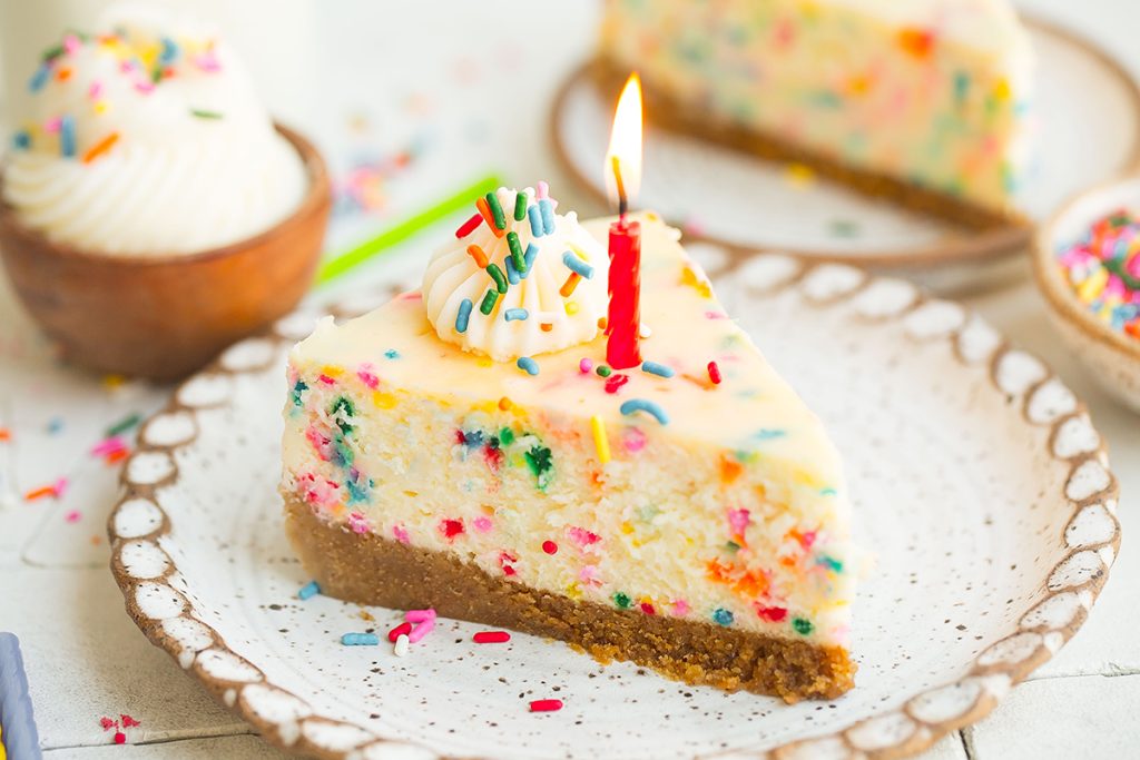slice of birthday cheesecake with candle