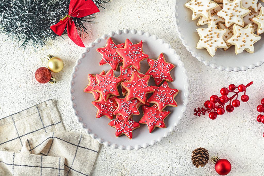 overhead shot of plate of red christmas sugar cookies