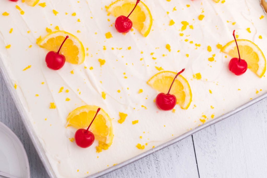 overhead shot of cake topped with lemon slices and cherries