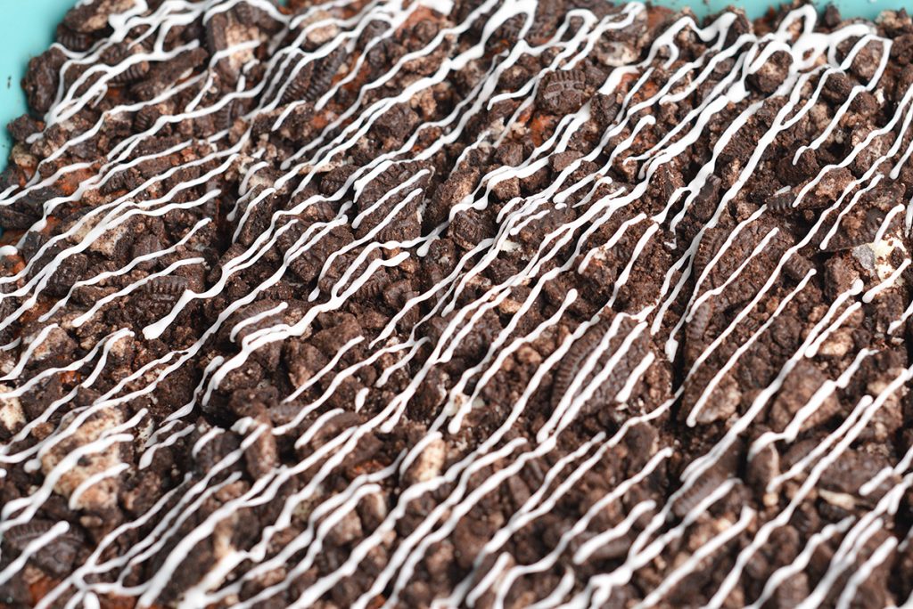 close up of pan of brownies drizzled with icing