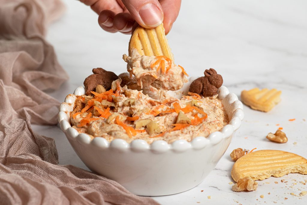 cookie dipping into carrot cake dip