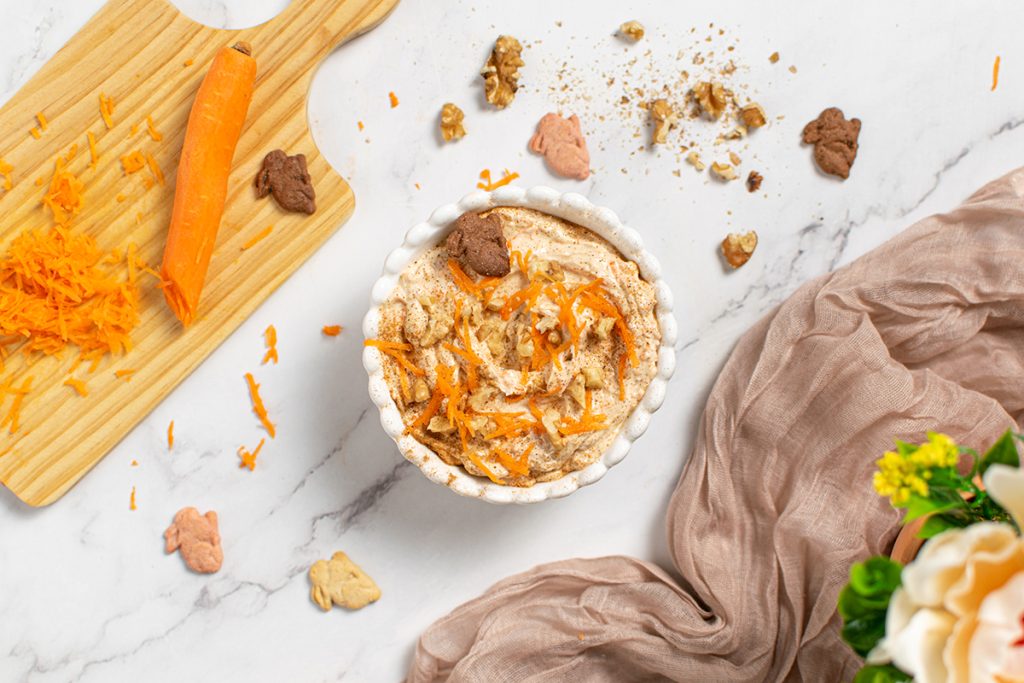 overhead shot of carrot cake dip with cutting board and carrots