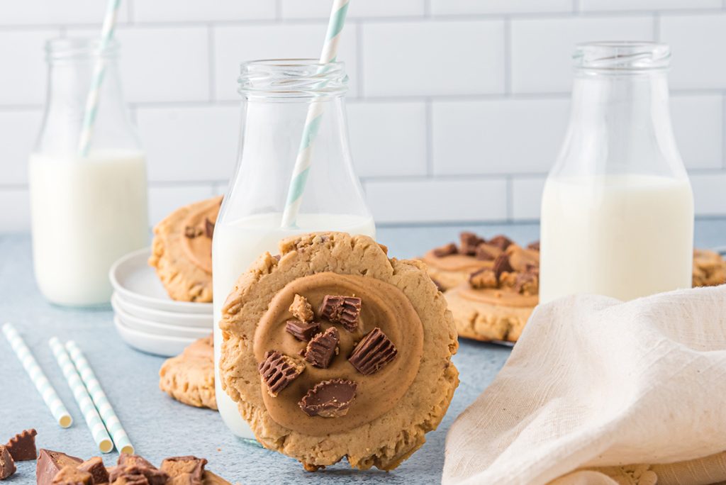 peanut butter cookie leaning on glass of milk