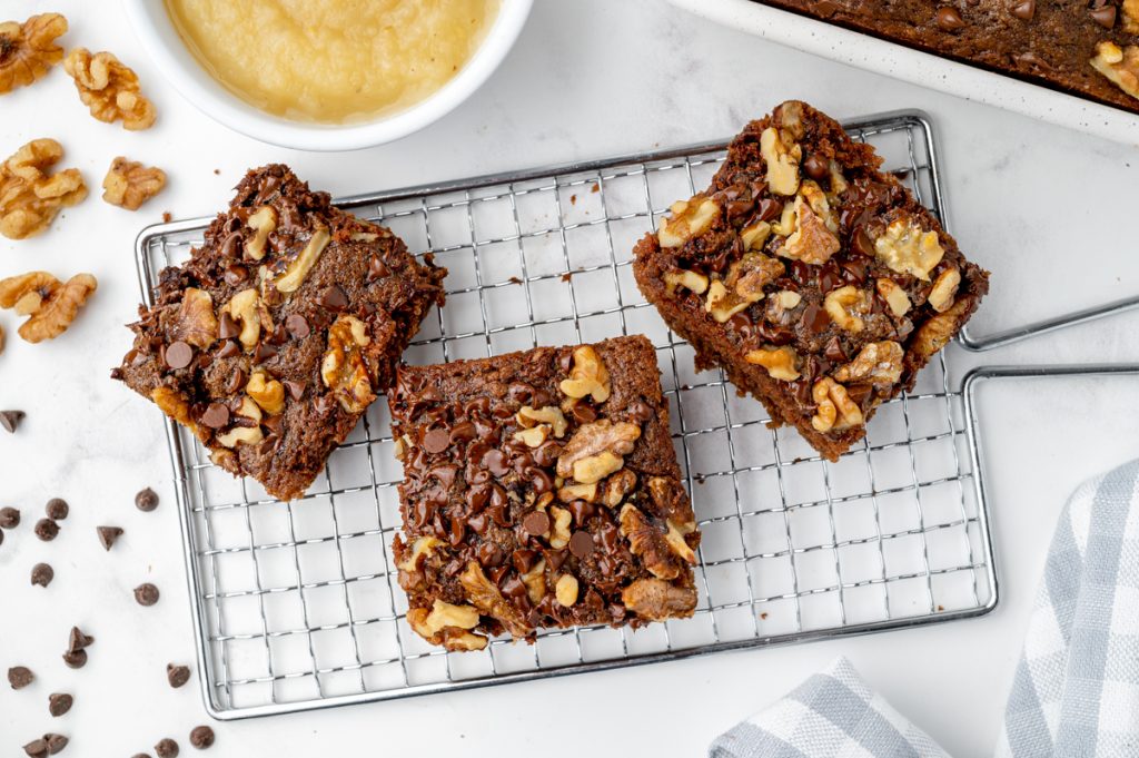 three applesauce brownies on a cooling rack