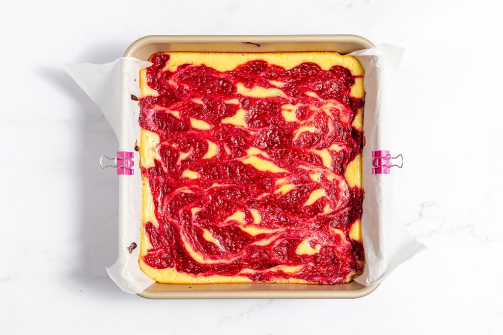 overhead shot of baked raspberry cheesecake in a pan