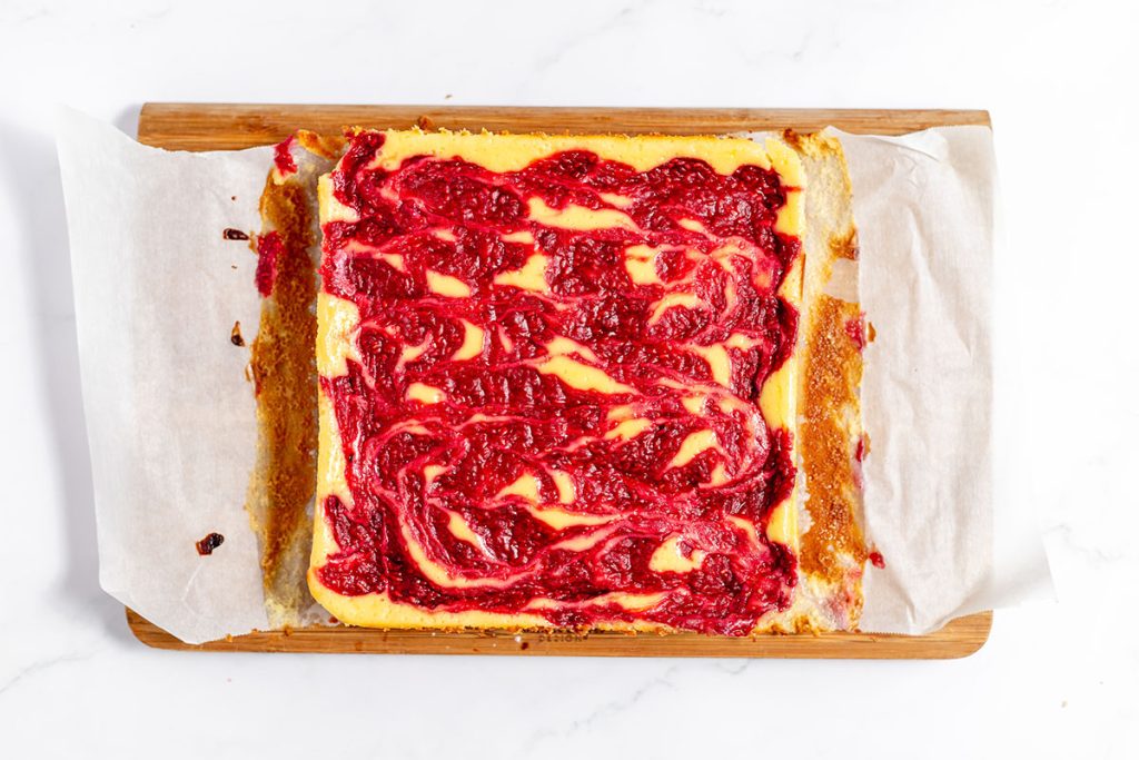 baked raspberry cheesecake on a cutting board