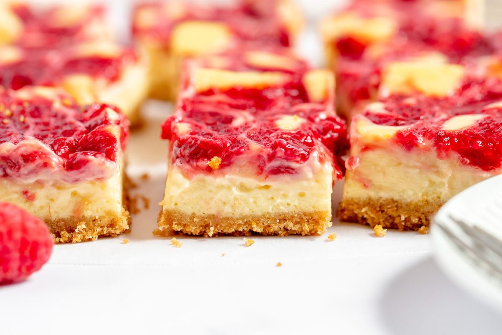 straight on shot of sliced raspberry cheesecake bars