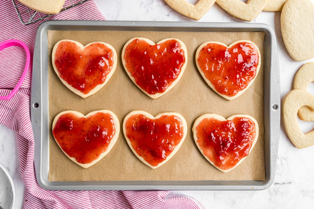 overhead shot of jam spread onto heart shaped cookies