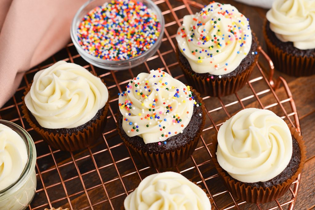 angled shot of chocolate cupcakes with frosting and sprinkles