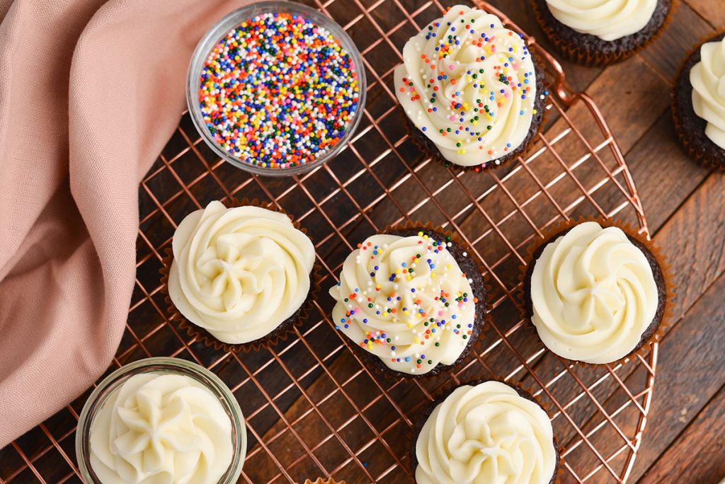 overhead shot of chocolate cupcakes with frosting and sprinkles