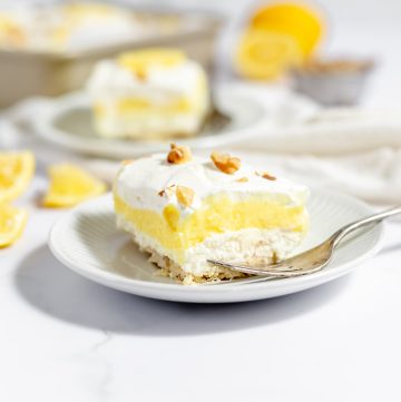 straight on shot of layered lemon dessert on plate with fork