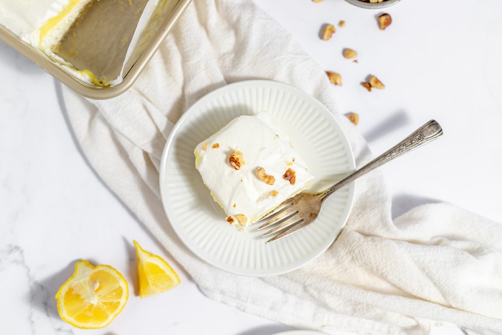 overhead shot of slice of lemon lush on white plate with fork