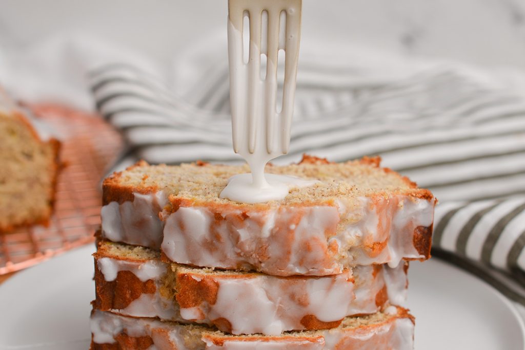 fork dripping icing on banana bread