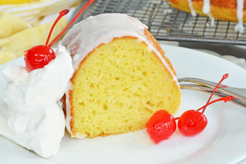 close up of slice of 7up cake with cherries on plate