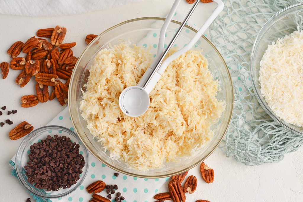 coconut ball mix in a bowl with a cookie scoop