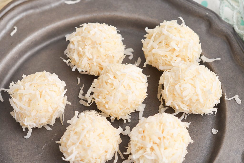 close up of no-bake coconut balls on a plate